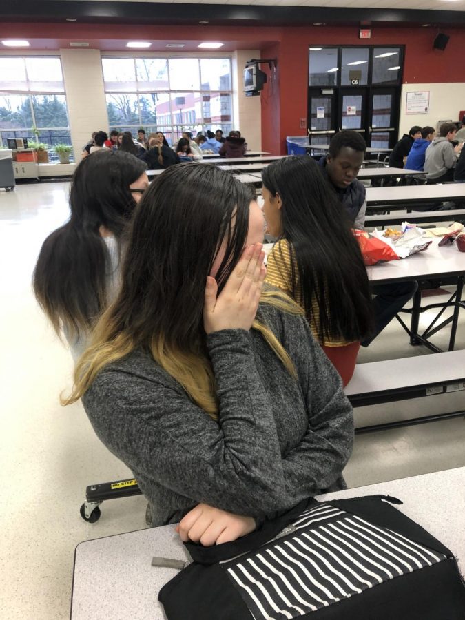 Student Sara Grossi hides her face from the camera during lunch.