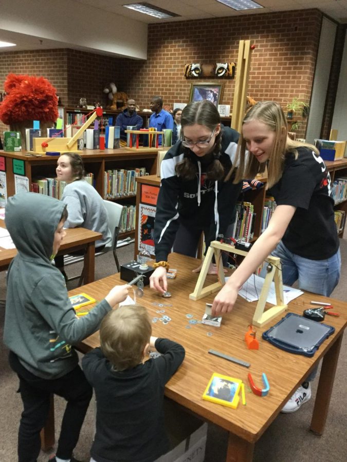 Josie Krepps and Nina Chavis showing students at Balls Bluff how magnets work on Science Night