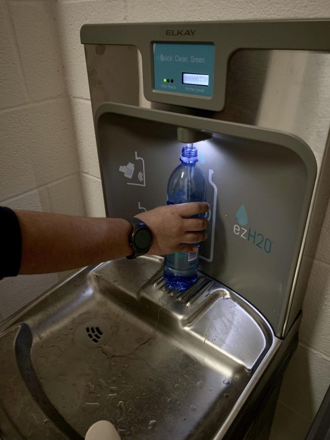 Andrew Budhai fills up his water bottle in one of the new water bottle fillers around the school.
