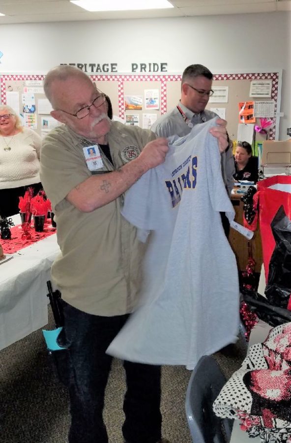 Mr. Ford opens up another farewell gift: his first Loudoun County Raiders T-shirt. Mr. Ford will be working as the building engineer at LCHS starting March 21, 2019.