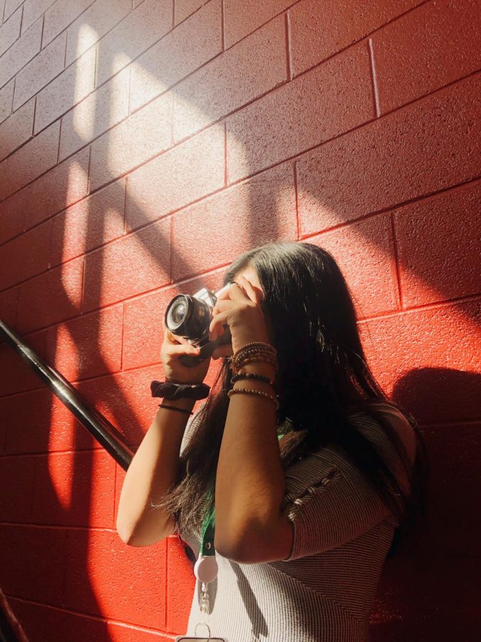 Sophomore, Devany Rodriguez, takes a picture for yearbook in the staircase.