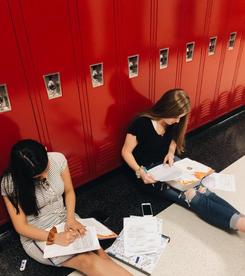Sophomore students, Michelle Andrade and Kaitlyn Hammond, sit in the hall together to work on classwork.