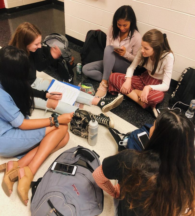 Sophomore students hang out during whole school lunch, working and studying together.