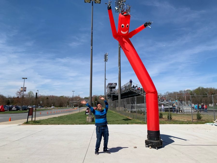 Anthony Galan, a senior, dances with the tube man at the field.